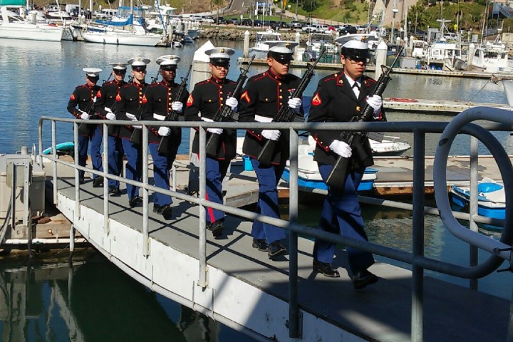 a group of people on a dock next to a body of water