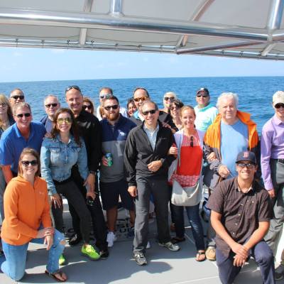 a group of people posing for a photo in front of water