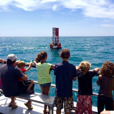 a group of people standing next to a body of water